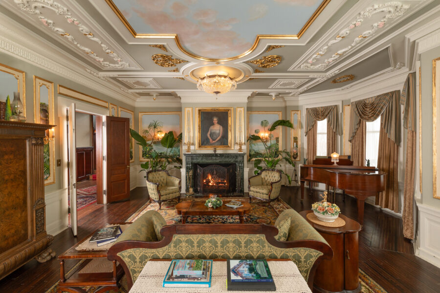 The drawing room at 300 Clifton in Minneapolis with a hand-painted ceiling mural, gold plaster detailing, marble fireplace and period furnishings