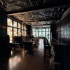 The dimly lit speakeasy-style bar room at the Pillsbury Club in Minneapolis, with carved oak paneling, stained glass windows and a chandelier.
