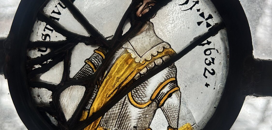 A seventeenth-century painted glass roundel in a Pillsbury Mansion window showing a standing figure in silver armour with a gold sash, lettered GUSTAVUS ADOLPHUS with the years 1611 and 1632.